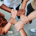 Un groupe de personnes formant un cercle avec leurs mains entrelacées pour symboliser la solidarité.