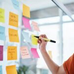 Femme écrivant des idées sur des post-it