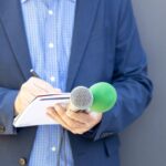 Journaliste prenant des notes avec micros