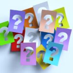 Des cartes colorées avec un point d'interrogation en relief sur une table