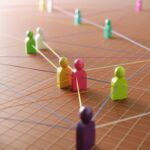 Des figurines connectées par des fils sur une grille représentant un réseau social