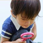 Enfant avec une loupe.
