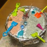 Un petit bac à sable avec pèles colorées