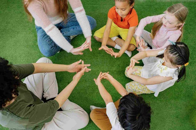 Ronde enfant et parent assis sur l'herbe en séance de sophrologie