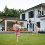 Un père porte un de ses enfants et cours avec les autres dans le jardin