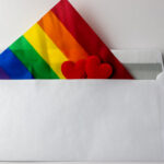 Une enveloppe avec une carte en tissu aux couleurs LGBT+ et deux petits coeurs