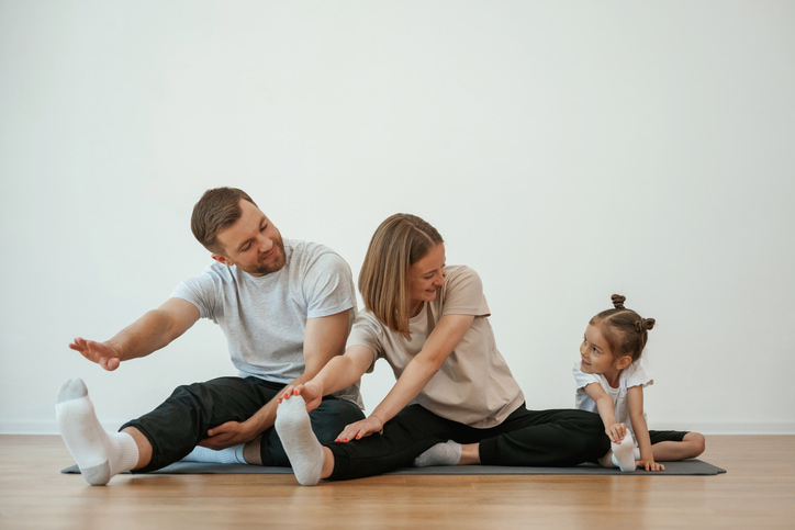 Un père et une mère font du yoga avec leur petite fille