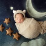 Un bébé dort avec un décor lune et étoiles