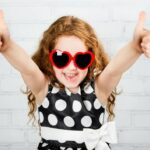 Fillette heureuse approuve les pouces en l'air