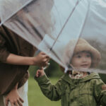 Photo d'une maman protégeant son enfants avec un parapluie (Jupilu)