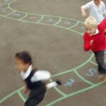 Une photo d'enfants qui jouent à la marelle dans une cours de récréation